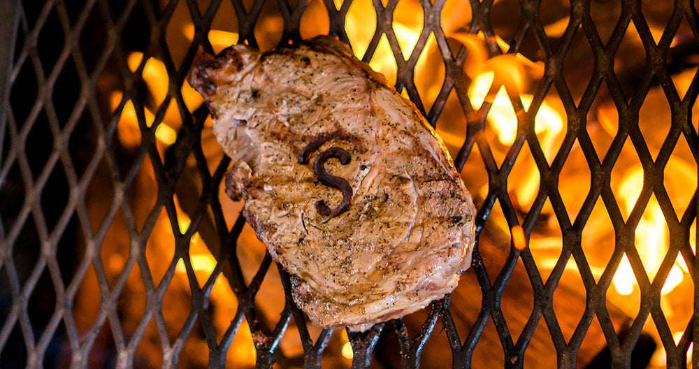 Steak on a hot grill with Covered S brand